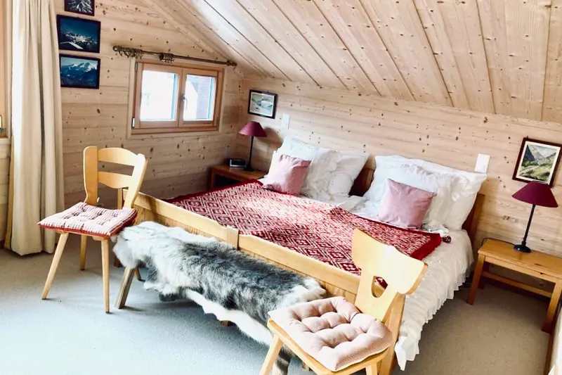 Slaapkamer onder het dak, met tweepersoonsbed en een vacht
