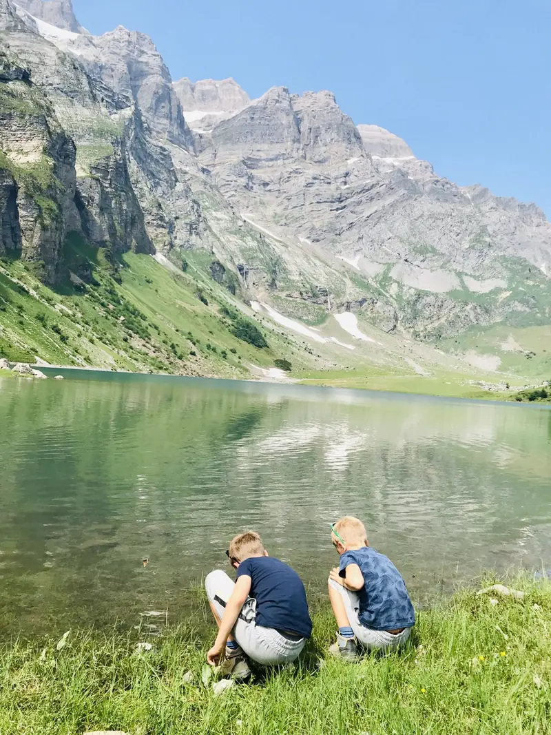 Twee kinderen aan de oever van een bergmeer